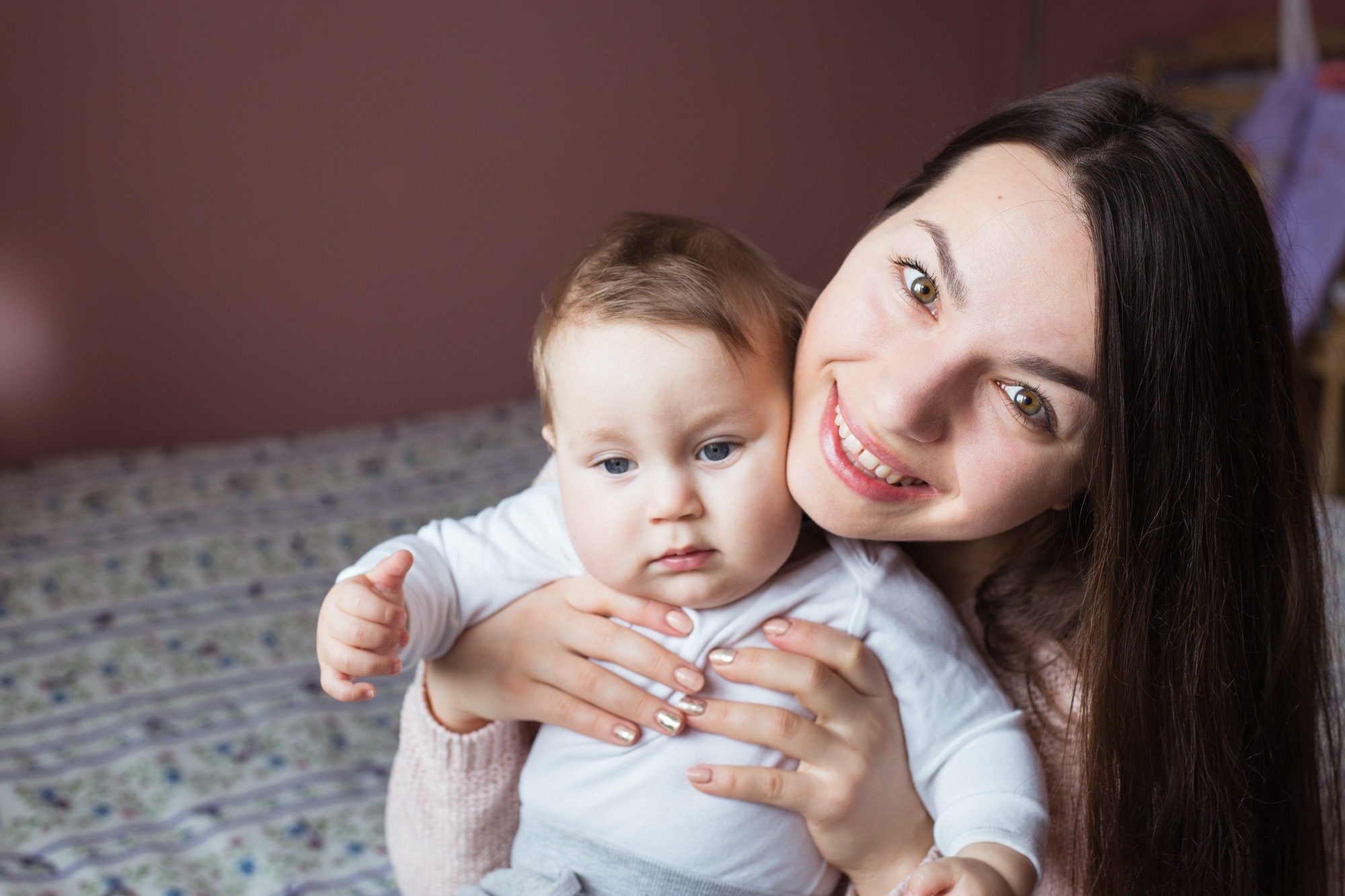 family, happy smiling young mother with little baby at home